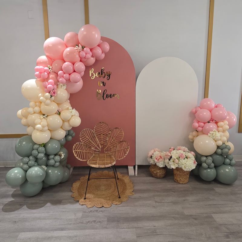 Baby in Bloom backdrop with sage, blush and cream balloons and a rattan chair