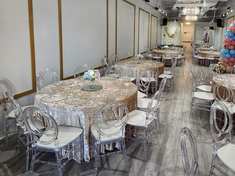 Vista del salón completo: mesas redondas con manteles de lentejuelas color champán, bajoplatos con borde de perlas y centros de mesa de flores
