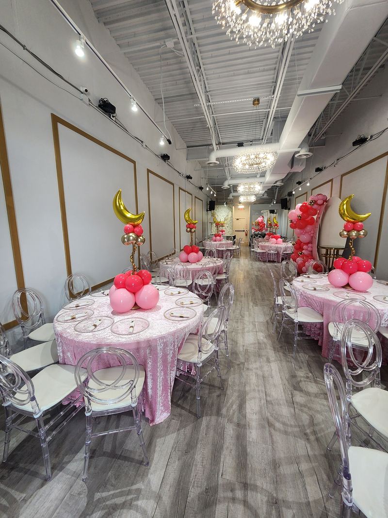 Girl baby shower tables with light pink linens, moon balloons and pink centerpieces
