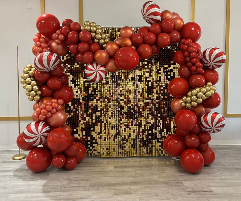 Fondo para fiesta navideña con globos rojos y dorados, globos de bastón de caramelo y una pared de lentejuelas doradas